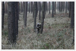 Getarnter Jäger auf der Pirsch in Kiefernwald