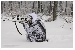 Getarnter Jäger im Winterwald