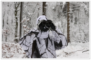 Jäger in Schneetarn mit Fernglas