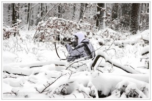 Jäger in Schneetarnanzug im verschneiten Wald