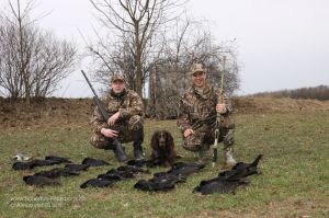 2 Jäger vor einer Strecke aus Rabenkrähen erlegt bei der Lockjagd am freundlichen Lockbild