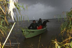 Jäger im Boot bei Regen