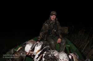 Jäger im Boot mit erlegten Gänsen und Enten