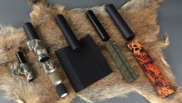Tarnband für Schalldämpfertarnung sowie Schalldämpfer-Schutzhüllen zum Vergleich auf einer Wildschweinscharte angeordnet.