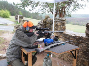 Ein Jäger hat sein Gewehr zum Einschießen mit Dreipunktauflage im Anschlag