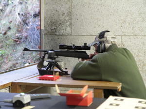 Ein Jäger auf dem Schießstand hat sein Gewehr mit Benchrestauflage und Arm fixiert