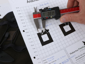 Ein Messschieber wird zum Ausmessen an den Abstand zwischen zwei Einschusslöchern gehalten