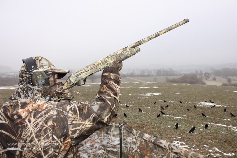 Krähenjagd - das Lockbild scheint zu passen Jäger mit Tarnanzug in Realtree Max-4 ® bei der Krähenjagd am freundlichen Lockbild aus beflockten Lockkrähen